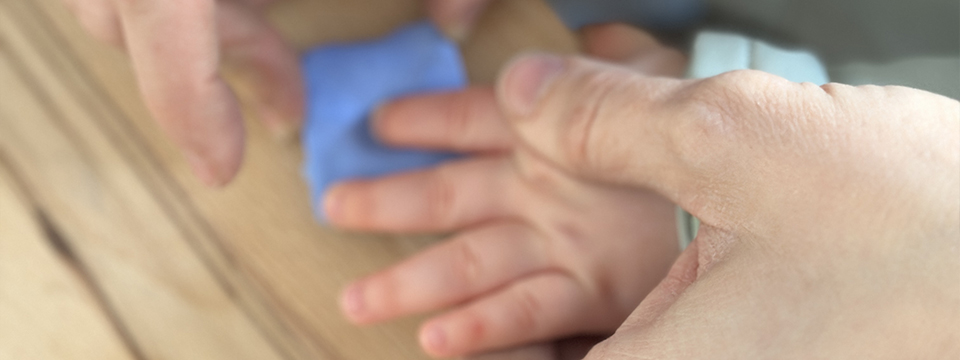 Photo d'un bébé et sa maman figeant un bijou empreinte bébé.